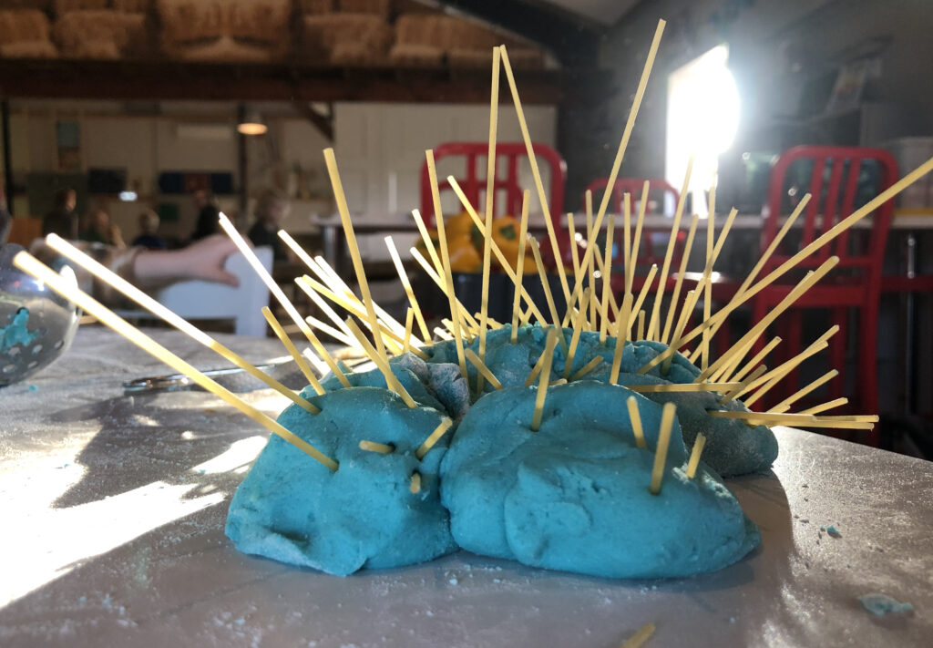 Hier zie je hoe er bij een creatieve workshop voor kinderen een uniek werk is gemaakt van zoutbrooddeeg met spaghetti bij Atelier Hier & daar