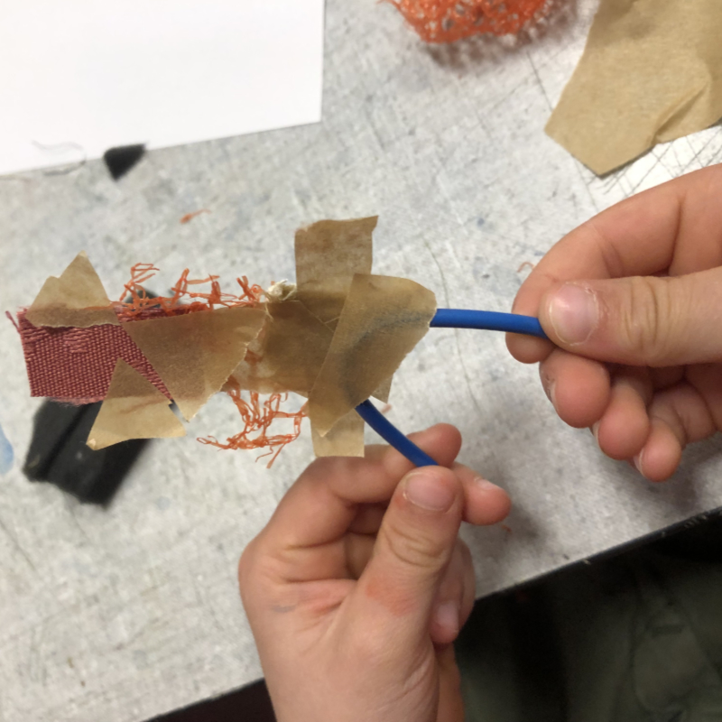 Van elektradraad, stof en plakband een figuurtje gemaakt bij Atelier Hier & daar