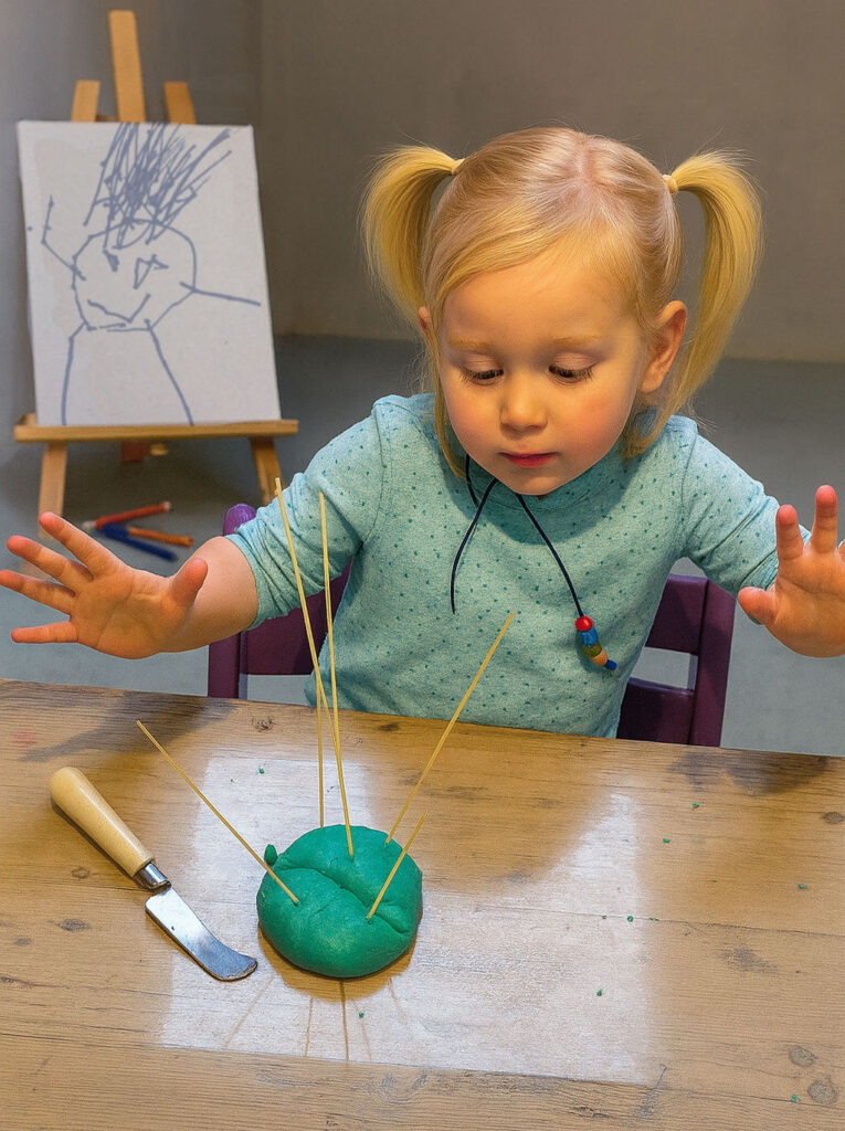 Kind in volle focus bij het spelen en onderzoeken van klei. Echte creativiteit bij Atelier Hier en daar